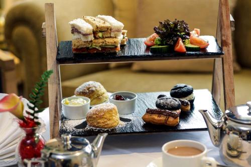 a plate of pastries on a shelf with cups of coffee at Tiverton Hotel Lounge & Venue in Tiverton