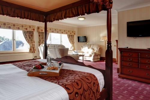 een slaapkamer met een groot bed en een dienblad met fruit erop bij Lake District Castle Inn in Keswick