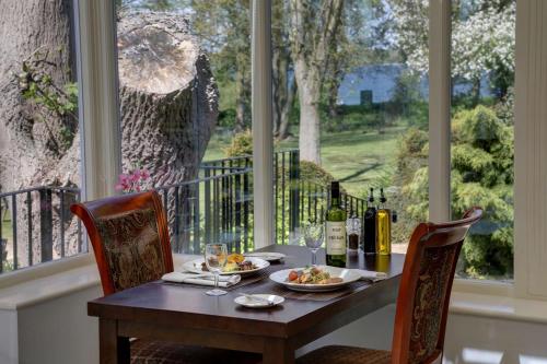 a table with a plate of food and bottles of wine at Normanton Park Hotel, Sure Hotel Collection by Best Western in Oakham