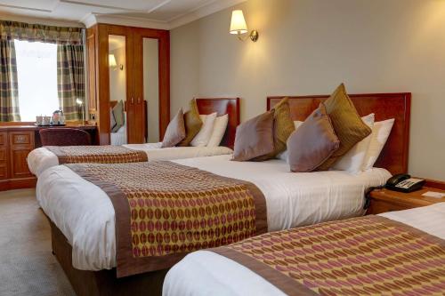 a hotel room with three beds in a room at Best Western Plus Pinewood Manchester Airport-Wilmslow Hotel in Handforth