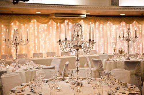 a room filled with tables and chairs with chandeliers at Aston Hall Hotel, BW Signature Collection in Sheffield
