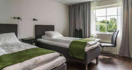 a hotel room with two beds and a window at Best Western Hotel Vrigstad in Vrigstad