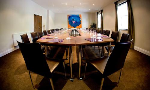 a conference room with a large wooden table and chairs at Aston Hall Hotel, BW Signature Collection in Sheffield