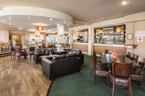 a restaurant with couches and tables and a bar at Best Western The Dartmouth Hotel, Golf & Spa in Dartmouth
