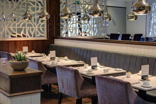 a dining room with tables and chairs and a mirror at The Croft Hotel in Darlington
