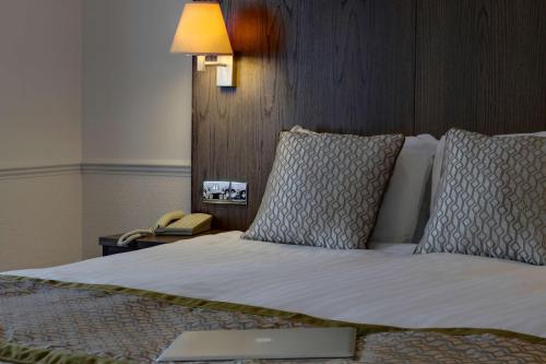 a bedroom with a bed with a lamp and a phone at Best Western Ipswich Hotel in Ipswich
