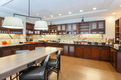 uma grande cozinha com armários de madeira e uma mesa de madeira em Hyatt Place Dallas/Grapevine em Grapevine