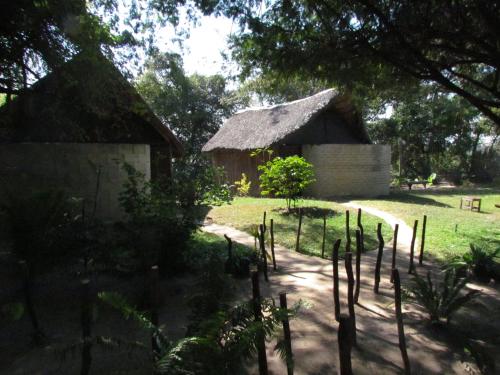 a house with a thatched roof in a yard at Caprivi Houseboat Safari Lodge in Katima Mulilo