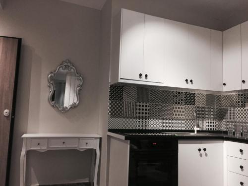 a kitchen with white cabinets and a black oven at Vivian House in Thessaloniki