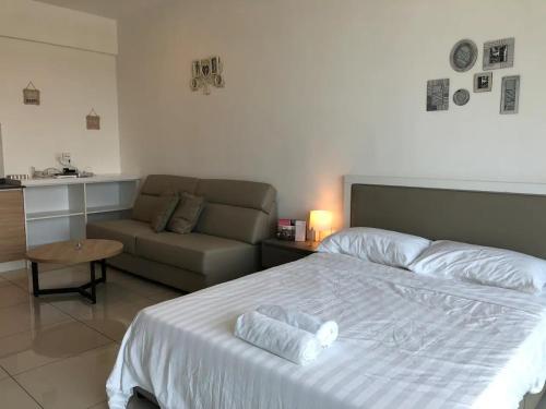 1 dormitorio con cama blanca y sofá en Heart of Bandar Baru Bangi (2), en Bangi