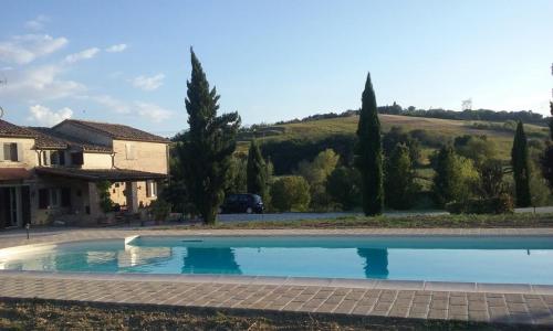 a large swimming pool in front of a house at Casa Sorgente in San Costanzo