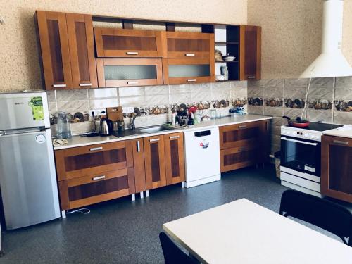 una cucina con armadietti in legno ed elettrodomestici bianchi di Hotel - Hostel Marichka a Chmil'nyk