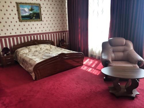 a bedroom with a bed and a chair and a table at LidoLux in Bălţi