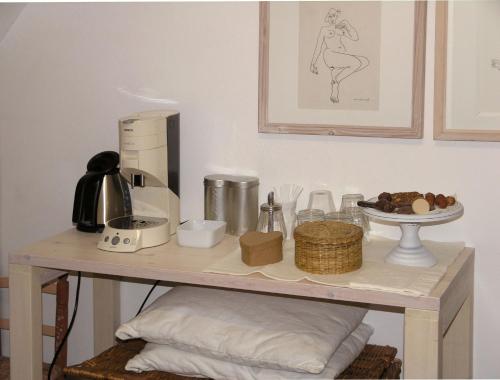 una mesa con cafetera y otros artículos. en B&B Singel 100, en Ámsterdam