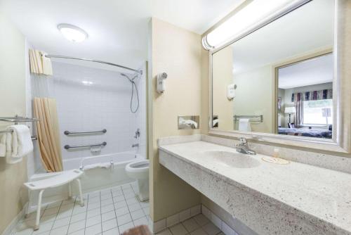 a bathroom with a sink and a toilet and a mirror at Days Inn by Wyndham Lexington Southeast in Lexington