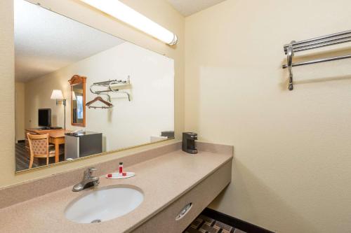 a bathroom with a sink and a large mirror at Super 8 by Wyndham Indianapolis-Southport Rd in Indianapolis