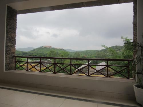 a window with a view of the mountains at Devra Udaipur in Udaipur