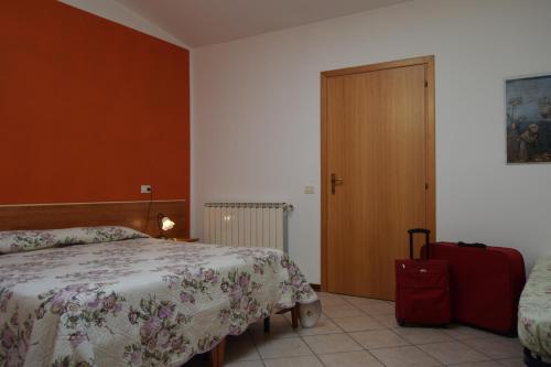 una camera con un letto e una valigia rossa di IL TURRIONE "app. Santa Chiara" ad Assisi