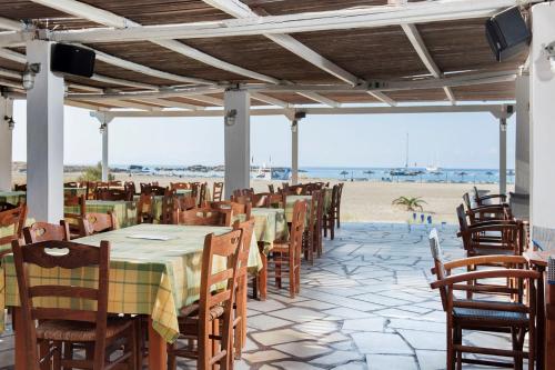 a row of tables and chairs on the beach at Dimitris Rooms in Manganari