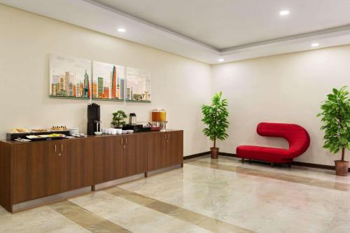a waiting room with a red chair and a letter s at Ramada Encore by Wyndham Kuwait Downtown in Kuwait