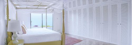 a bedroom with a canopy bed and a window at Villa Santé by The Serendipity Collection in Kalpitiya