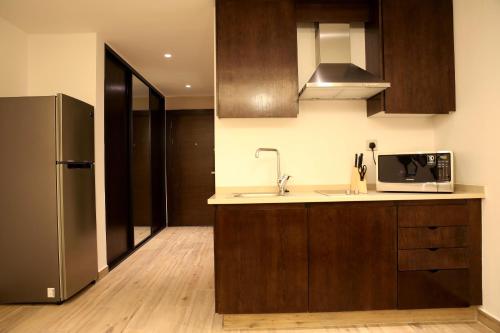 a kitchen with a sink and a refrigerator at Downtown Hotel Apartments in Amman