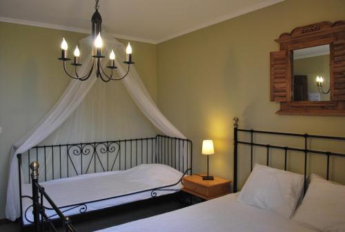 ベルトリにあるPetite Reineのベッドルーム1室(シャンデリアと鏡付きのベッド1台付)