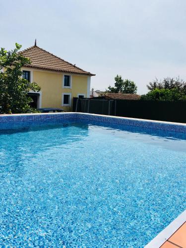 a large blue swimming pool in front of a house at casadaeiradeangeja in Angeja