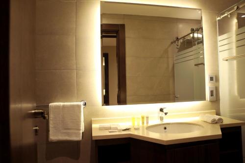 a bathroom with a sink and a mirror at Downtown Hotel Apartments in Amman