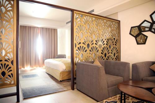 a hotel room with a bed and a couch and a mirror at Downtown Hotel Apartments in Amman