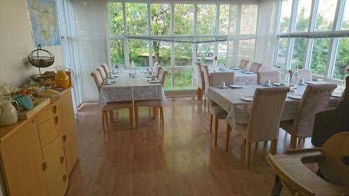 jadalnia ze stołami, krzesłami i oknami w obiekcie Alba Guesthouse w Reykjavík