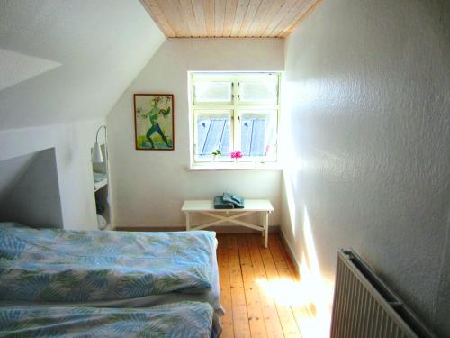 una piccola camera da letto con un letto e una finestra di Jernbanegade 13.1 a Thyborøn