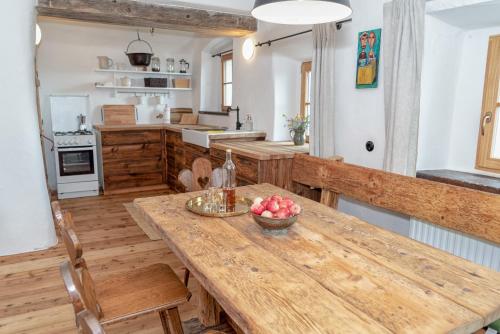 eine Küche mit einem Holztisch mit einer Schale Äpfel darauf in der Unterkunft Obiralmhütte Fladung in Bad Eisenkappel