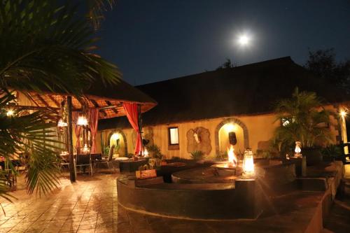 a house with a courtyard at night with a full moon at African Rock Lodge in Hoedspruit