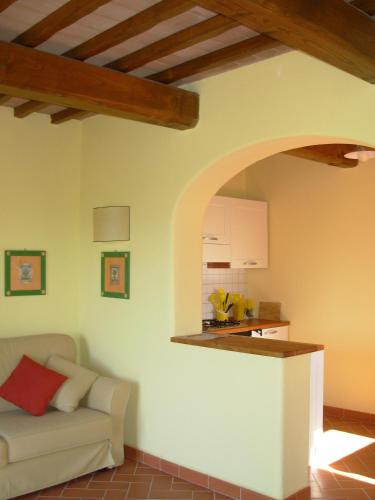a living room with a couch and a kitchen at Agriturismo Santa Rosa in Subbiano