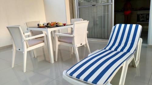 a white table with chairs and a table with food on it at Magic Beach Apartments in Kyrenia
