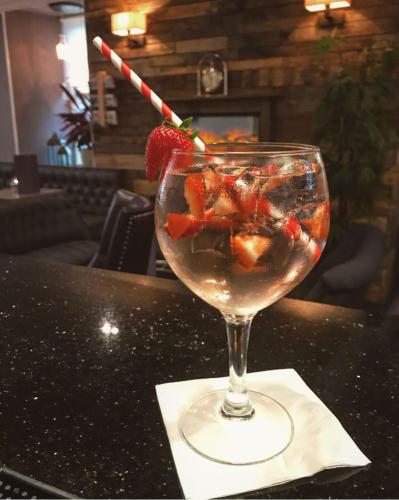 a drink with a strawberry in a glass on a table at The Fairburn Hotel in Mauchline