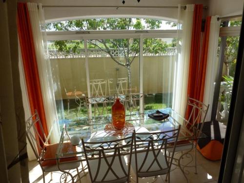 a glass table with a vase on it in a window at Villa Manet Portiragnes in Portiragnes