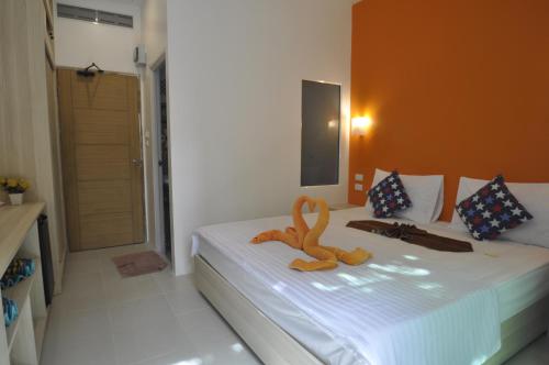 a bedroom with a bed with a stuffed animal on it at Duangjai Residence in Rawai Beach
