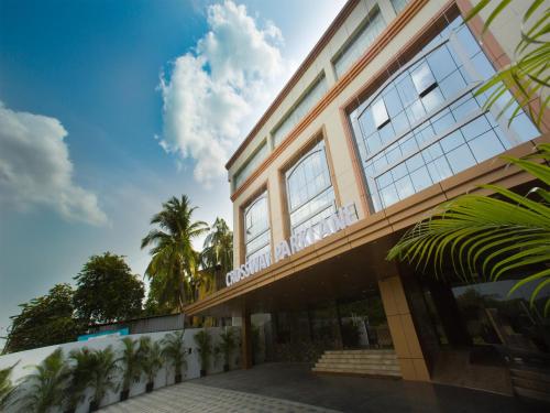 a building with palm trees in front of it at ST Parklane Airport Hotel Chennai in Chennai