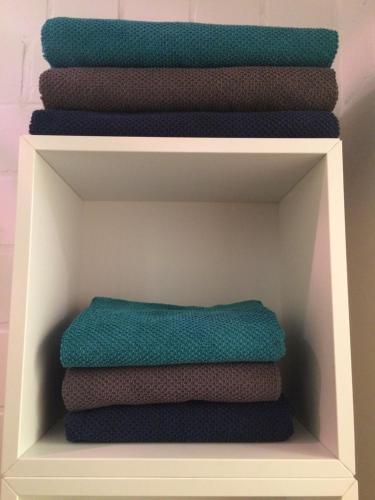 a stack of towels sitting on a shelf at Apartment Reetblick in Kiel