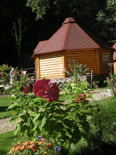 a small wooden cabin with a red flower in front of it at kotas-Esprit Nordique in Balaives-et-Butz