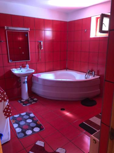 un bagno rosso con vasca e lavandino di Vila Khalo a Mangalia