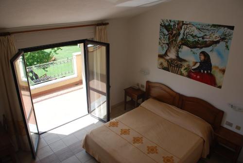 a bedroom with a bed and a sliding glass door at Hotel Belvedere Tonara in Tonara