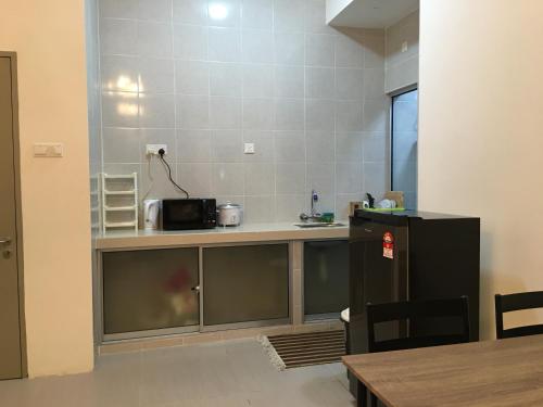 a kitchen with a counter with a microwave at Aalina's Comfort Home - Muslim Homestay in Cameron Highlands