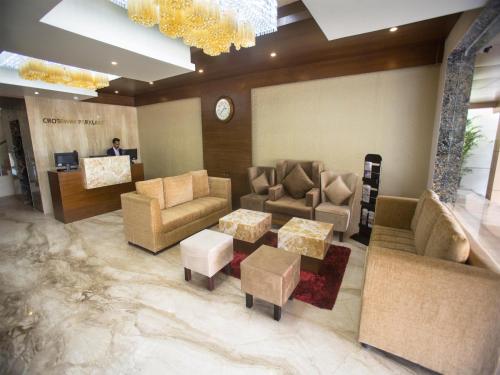 a lobby with couches and tables and a clock at ST Parklane Airport Hotel Chennai in Chennai