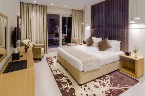 a bedroom with a large bed and a living room at Waterfront One Bedroom Downtown in Dubai