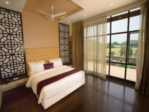 a bedroom with a bed and a large window at ST Parklane Airport Hotel Chennai in Chennai