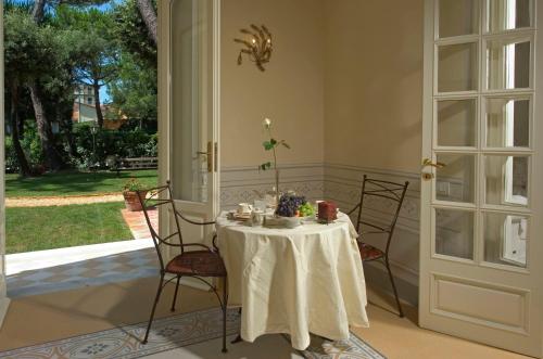 a table with chairs and a white table cloth on it at Villa Signori in Marina di Pietrasanta