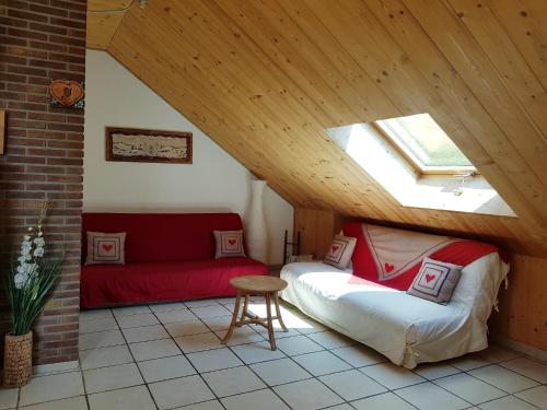 a attic room with a bed and a couch at L'Alpage in La Chal